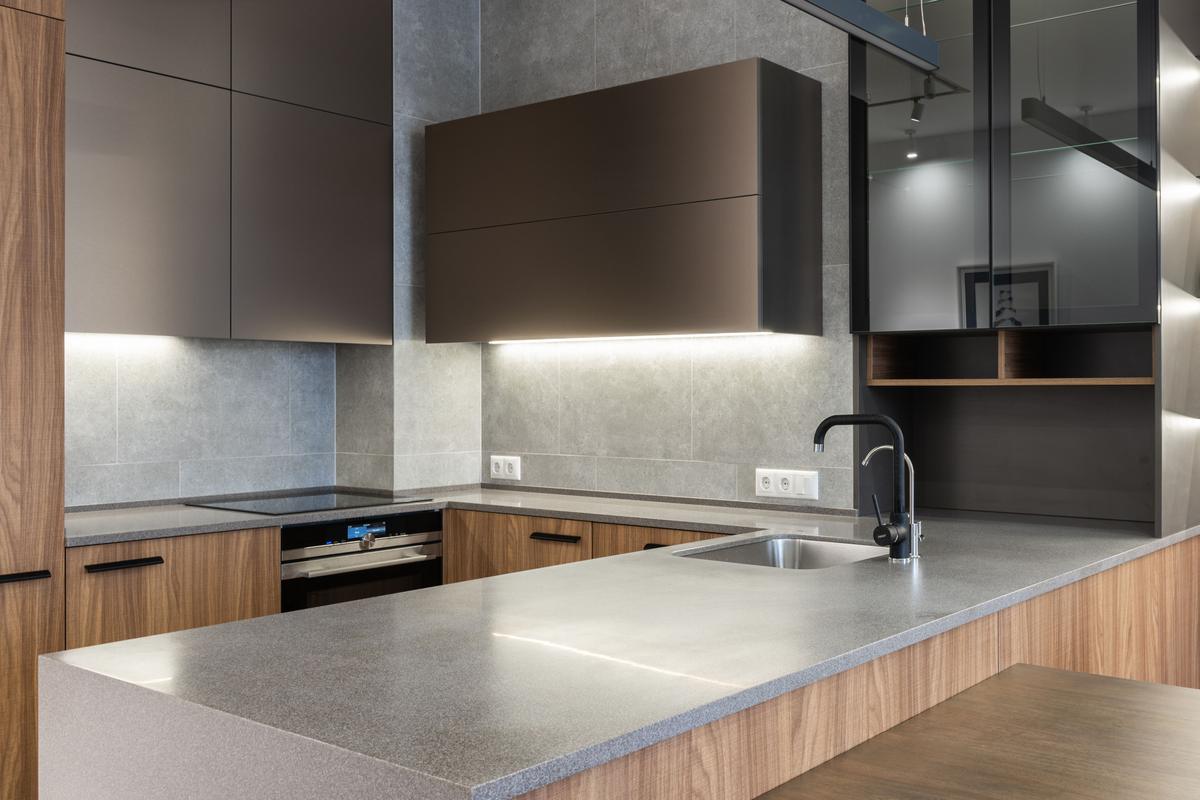 Modern kitchen with dark upper cabinets and a stone and wood island
