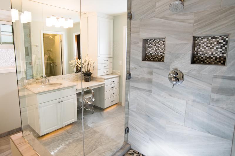 Walk-in shower with large gray tile, two mosaic tile niches and a ceiling rain shower head