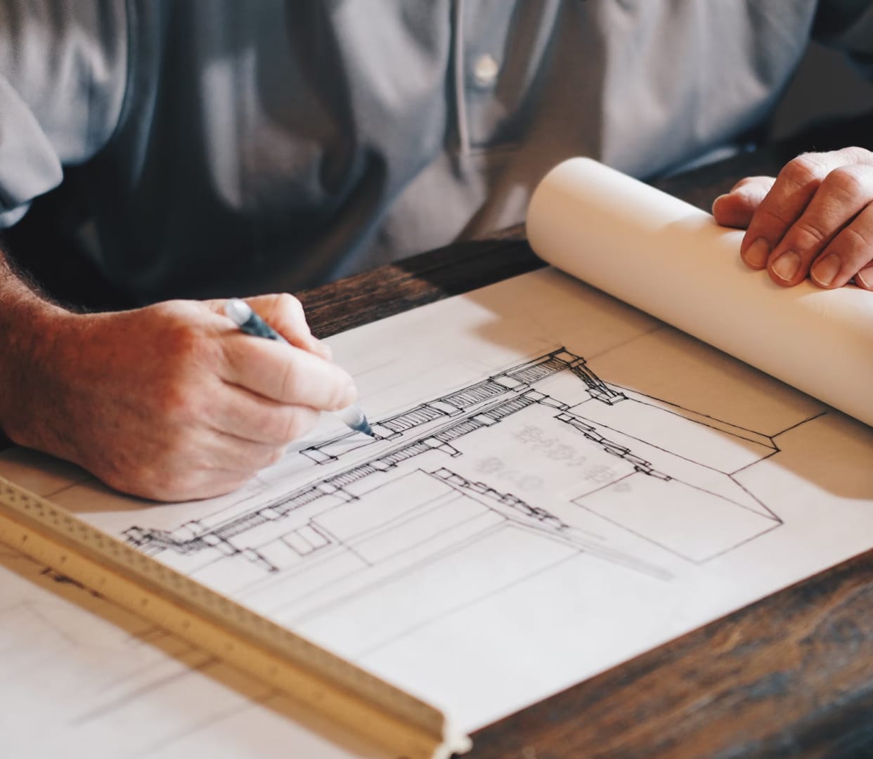 Man drawing a set of plans for a construction project