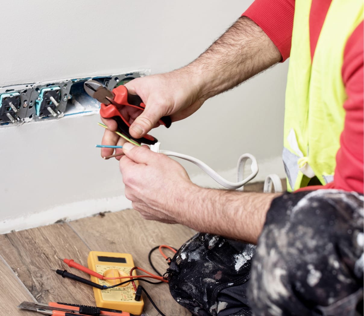 Electrician working on the wiring of a household outlet